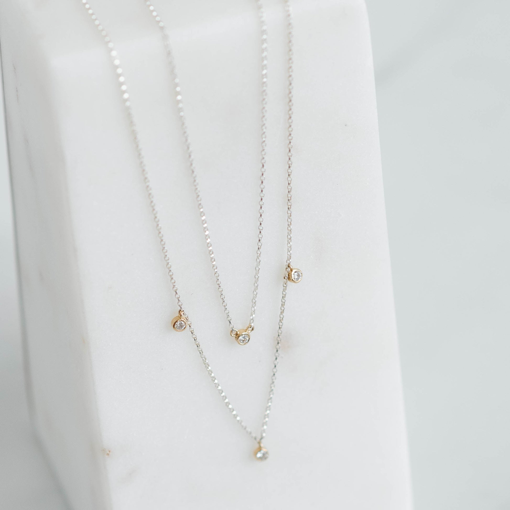 double silver rolo chain with four lab grown round brilliant set in yellow gold bezels.