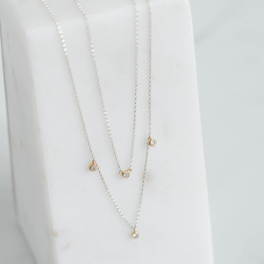 double silver rolo chain with four lab grown round brilliant set in yellow gold bezels.