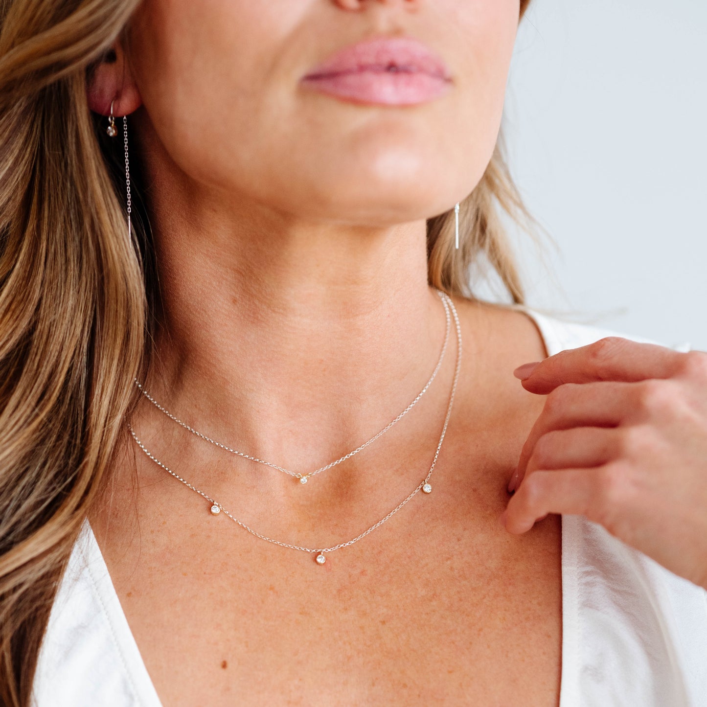 Close-up of a woman wearing a delicate necklace with a blurred background