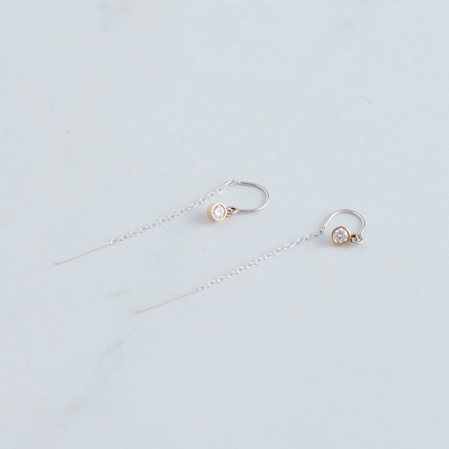 silver threader earrings with a 3mm lab grown round brilliant set in 10K yellow gold bezel settings.
