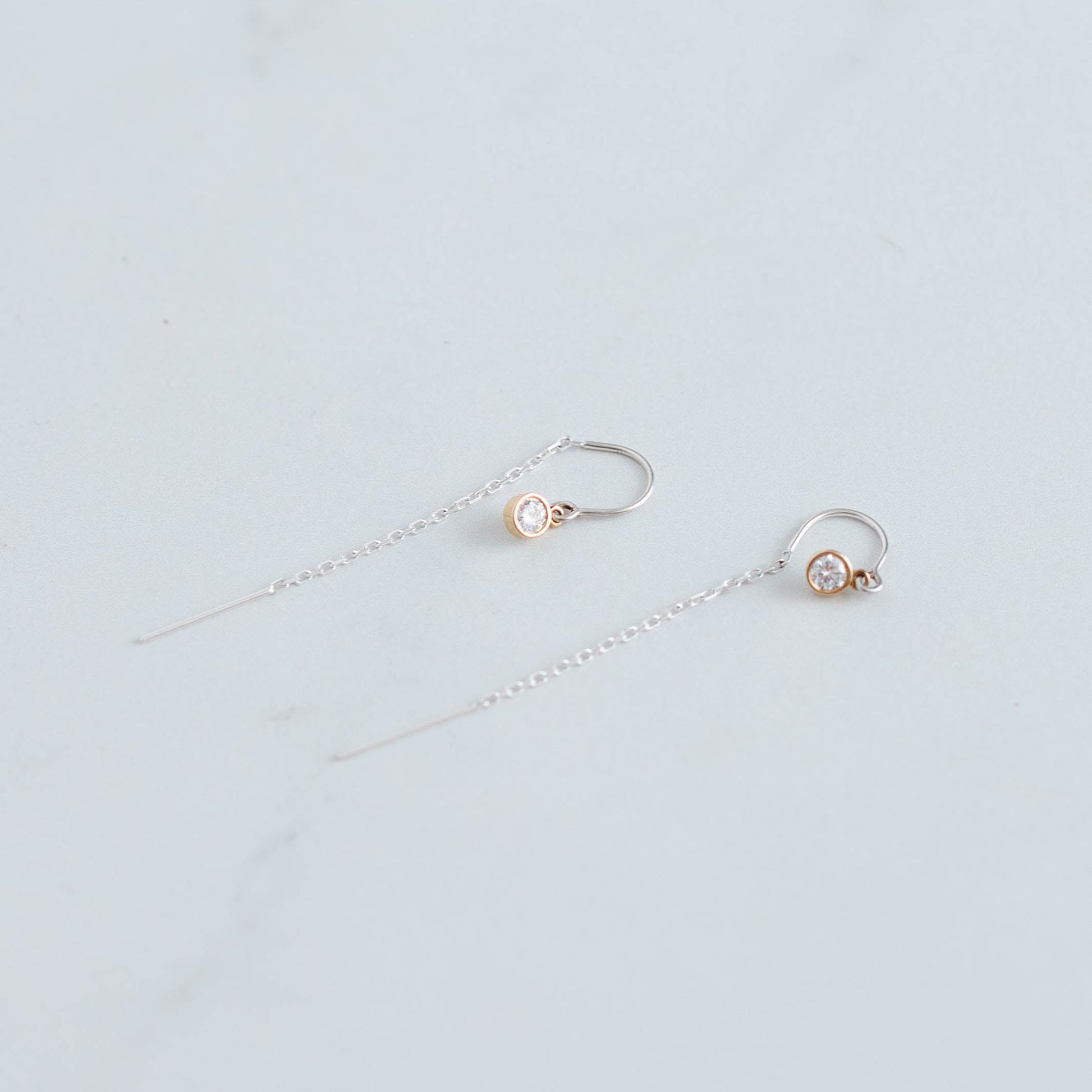 silver threader earrings with a 3mm lab grown round brilliant set in 10K yellow gold bezel settings.