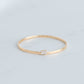 Solid gold bangle with an emerald cut lab grown diamond set in a yellow gold bezel.