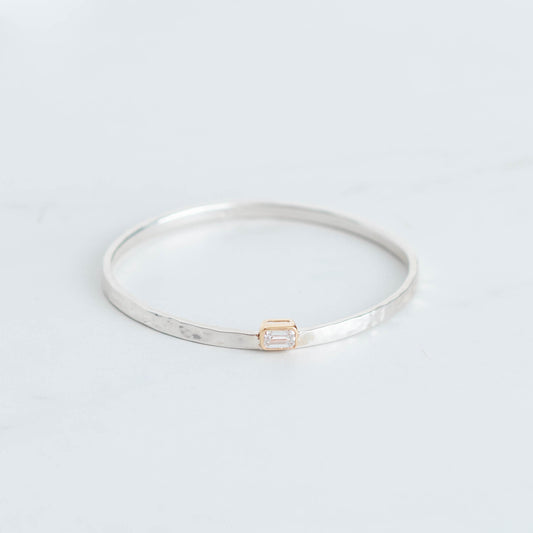 Silver bangle with a hammered finish and a 1ct lab grown emerald cut diamond set in 10K yellow gold bezel