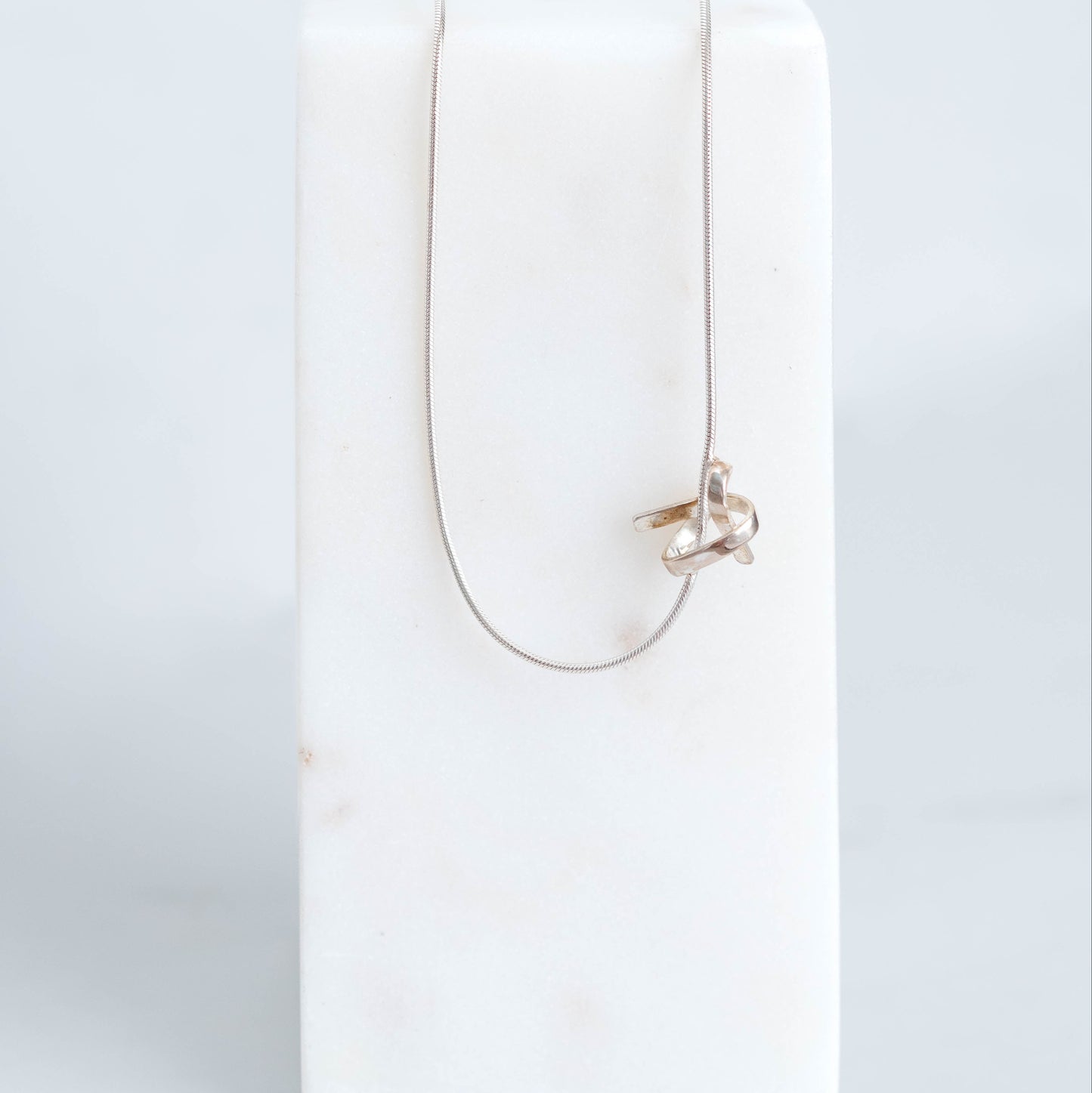 Handmade silver know pendant suspended on a silver snake chain at 18inchs. 