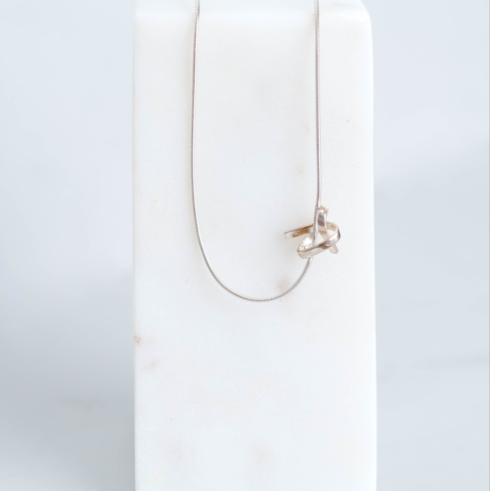 Handmade silver know pendant suspended on a silver snake chain at 18inchs. 