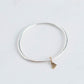 Thick silver bangle with gold dangling heart charm 